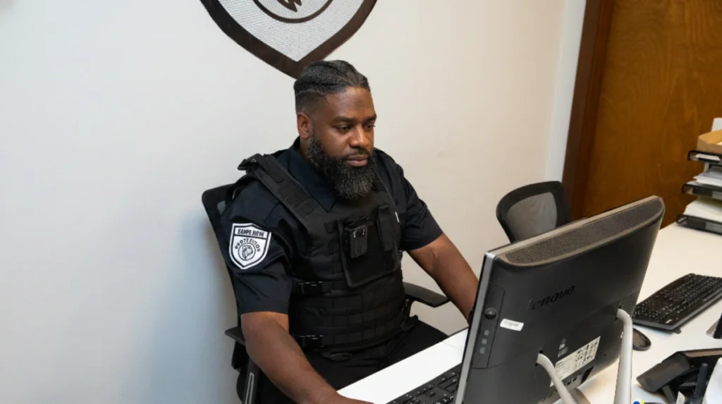 A Carpe Diem Protection security officer wearing a professional uniform and company badge, representing trained security personnel and reliable protection services for commercial properties and businesses in the Seattle area.